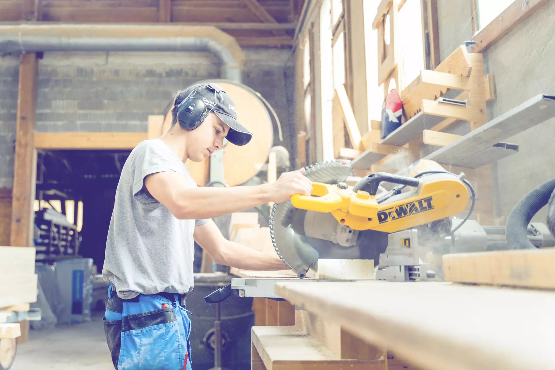 Apprenti charpentier en train de découper des bouts de bois