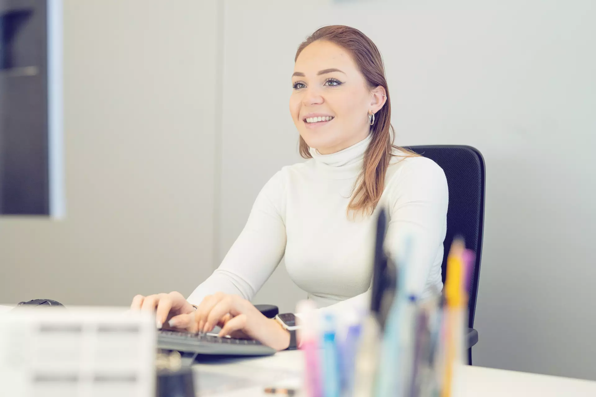 Apprentie employée de commerce devant son ordinateur