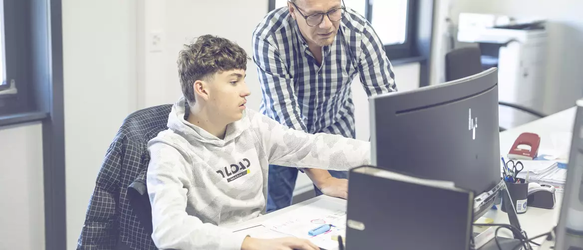 apprenti dessinateur montrant quelque chose à son formateur sur l'ordinateur