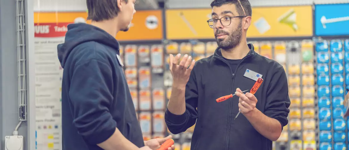Apprenti gestionnaire de commerce de détail et formateur en train de discuter dans un rayon