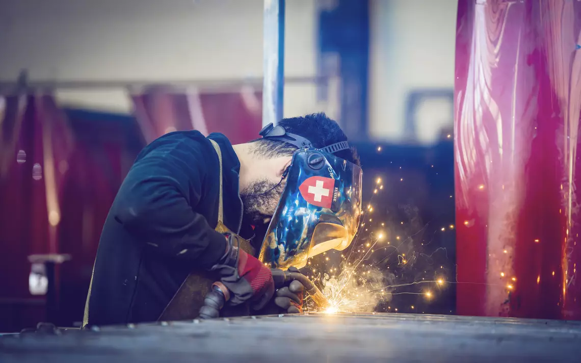 homme faisant de la soudure avec un casque. Des étincelles éclatant de son travail.